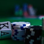 Close-up of playing cards and poker chips on a green felt surface