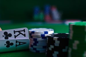 Close-up of playing cards and poker chips on a green felt surface
