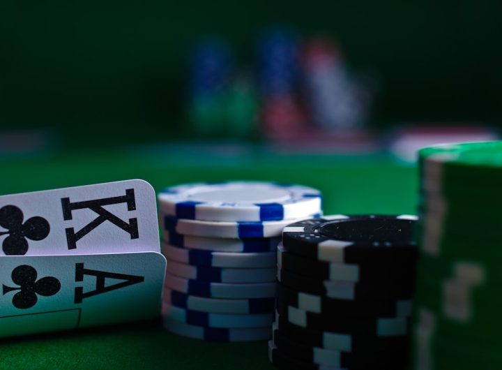 Close-up of playing cards and poker chips on a green felt surface